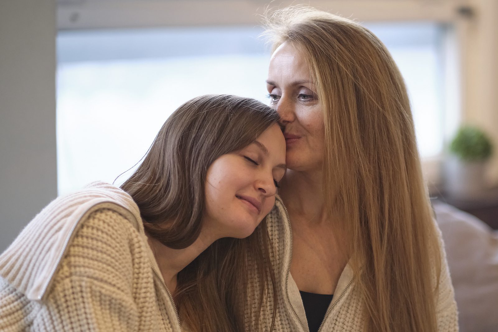 Happy Senior Mother Embracing Adult Daughter Laughing Together,